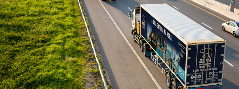 Caminhão refrigerado da Bora Transportes em rodovia, garantindo entregas seguras de alimentos com temperatura controlada.